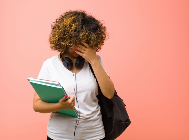 sembra stressato, vergogna o turbato, con mal di testa, coprendosi il viso con la mano