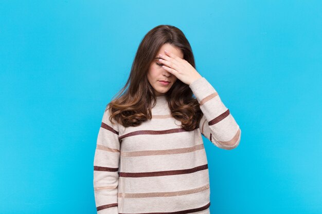 sembra stressato, vergogna o turbato, con mal di testa, coprendosi il viso con la mano