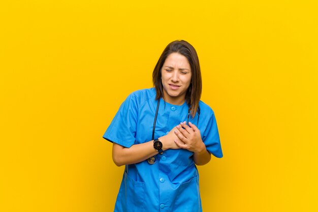 Sembra triste, ferito e con il cuore spezzato, tenendo entrambe le mani vicino al cuore, piangendo e sentendosi depresso isolato