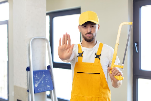 sembrando serio mostrando il palmo aperto facendo il gesto di arresto