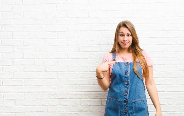 sembrare orgoglioso, fiducioso e felice, sorridendo e indicando se stesso o facendo il segno numero uno