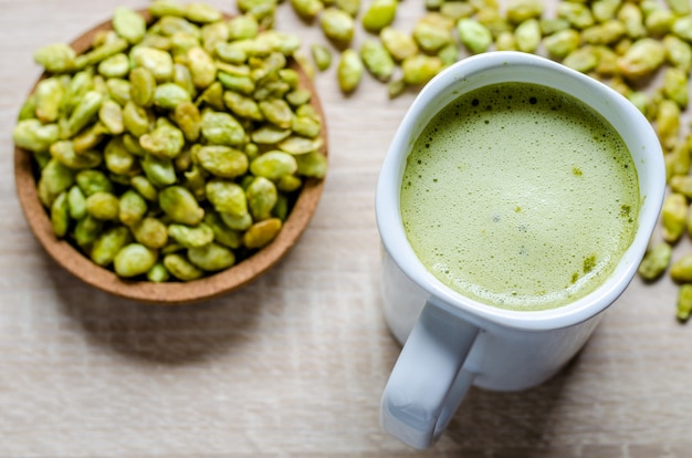 Semi commestibili dello spuntino del fagiolo del giacinto e del latte del tè verde su legno