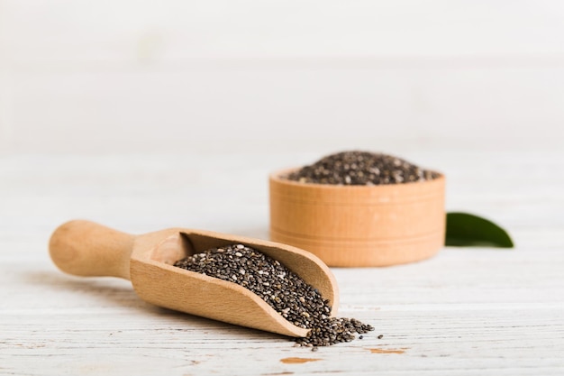 Semi di chia in ciotola e cucchiaio su sfondo colorato Salvia hispanica sana in una piccola ciotola Superfood sano