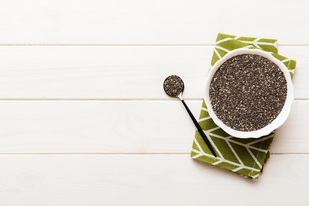 Semi di chia in ciotola e cucchiaio su sfondo colorato Salvia hispanica sana in una piccola ciotola Superfood sano