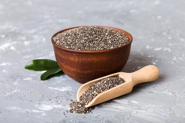 Semi di chia in ciotola e cucchiaio su sfondo colorato Salvia hispanica sana in una piccola ciotola Superfood sano