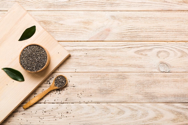 Semi di chia in ciotola e cucchiaio su sfondo colorato Salvia hispanica sana in una piccola ciotola Superfood sano