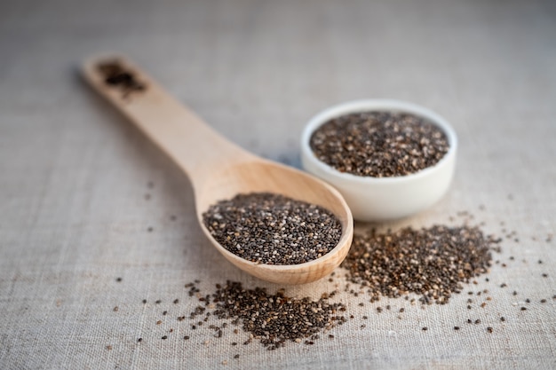 Semi di Chia in una ciotola e su un cucchiaio di legno sul tavolo