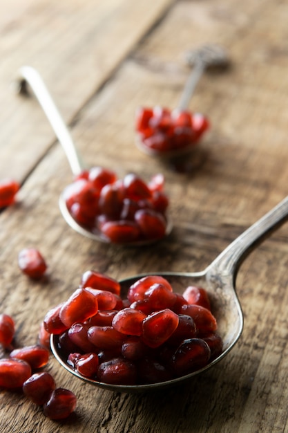 Semi di melograno, fondo in legno rustico. Detox, dieta, frutta.