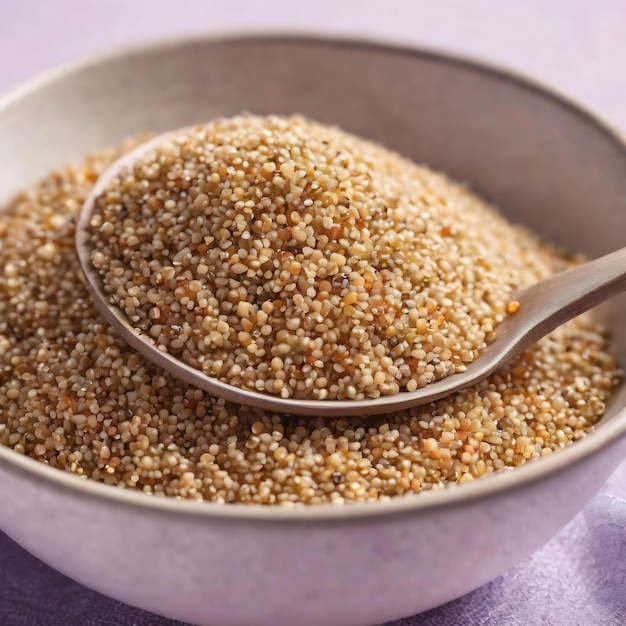 Semi di quinoa in ciotola e cucchiaio su sfondo colorato kinwa sano in piccola ciotola superfood sano