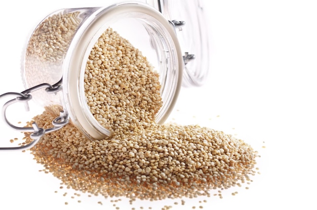 Semi di quinoa senza glutine crudi organici superfood in vaso di vetro ermetico primo piano su sfondo bianco