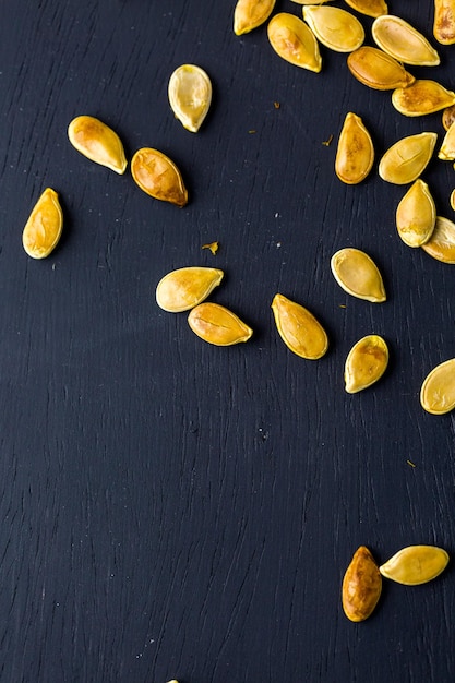 Semi di zucca cucinati in casa su sfondo nero.