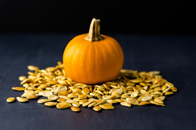 Semi di zucca cucinati in casa su sfondo nero.