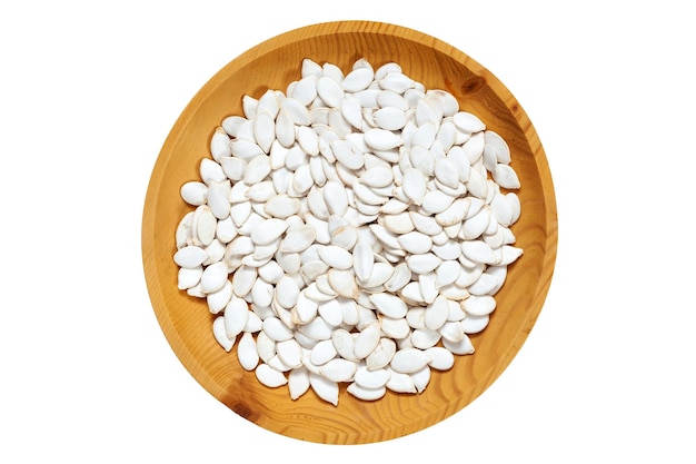 Semi di zucca non sbucciati in un piatto di legno di pino su sfondo bianco isolato Fila di ciotole con semi di zucca noci vista dall'alto Modello di semi di zucca non sbucciati