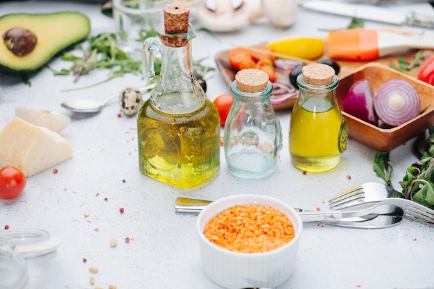 Semi in una tazza davanti a bottiglie di olio e altri ingredienti da cucina su un tavolo