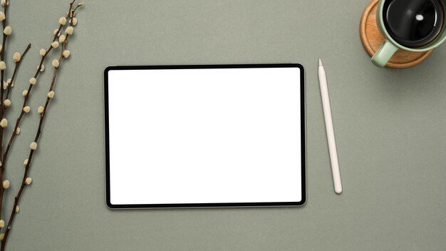 Semplice area di lavoro per ufficio con tazza da caffè con penna stilo per tablet con schermo bianco su sfondo grigio