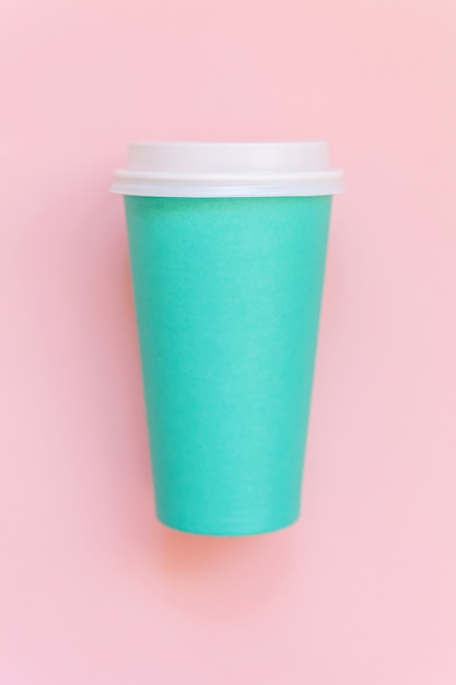 Semplicemente piatto design laici tazza di caffè di carta blu su sfondo rosa pastello colorato alla moda