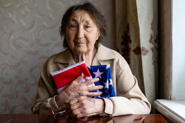 Senior che è orgogliosa di essere una donna molto anziana americana con bandiera americana.