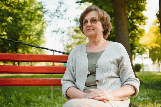 Senior donna che cammina nel parco in estate