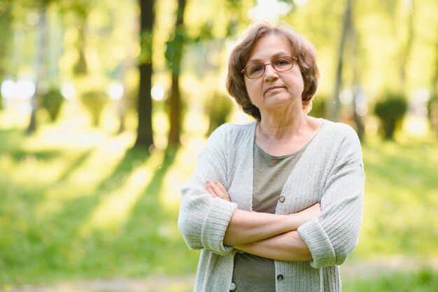 Senior donna che cammina nel parco in estate