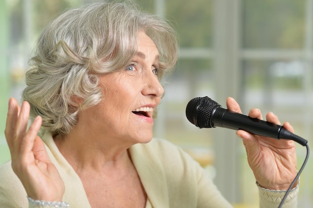 Senior donna che canta con il microfono