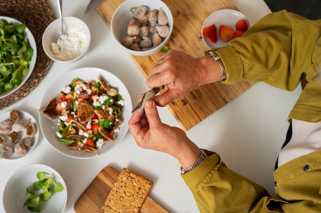 Senior donna che fa il piatto con i fichi in cucina