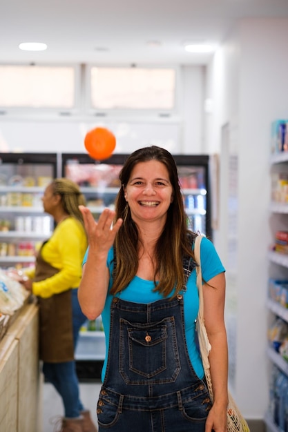 Senior donna che gioca con la frutta nel supermercato