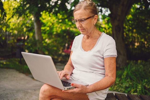 Senior donna che lavora in linea con il computer portatile