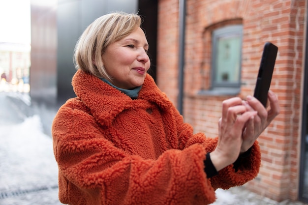 Senior donna che scatta una foto durante il suo incontro con gli amici