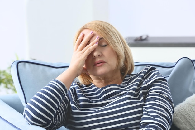 Senior donna che soffre di mal di testa a casa