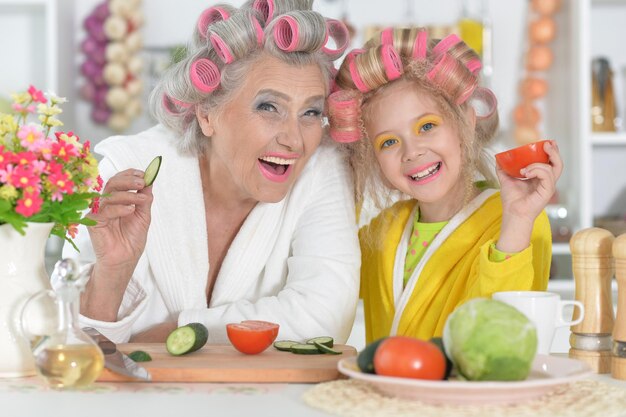 Senior donna e nipote in cucina con verdure