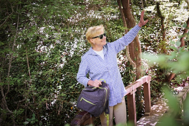 Senior donna escursioni nel sentiero nel bosco