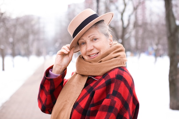 Senior donna in vestiti caldi all'aperto. Vacanze invernali