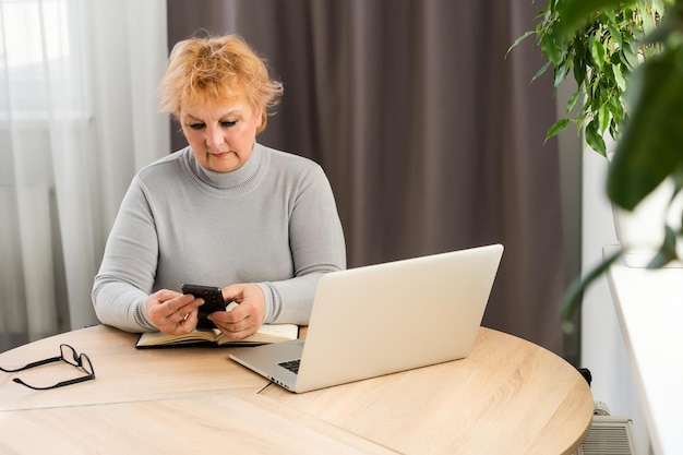 Senior donna shopping su internet, pagando con carta di credito.