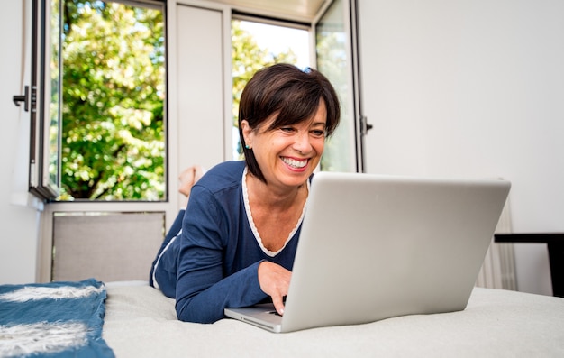 Senior donna utilizzando laptop a casa