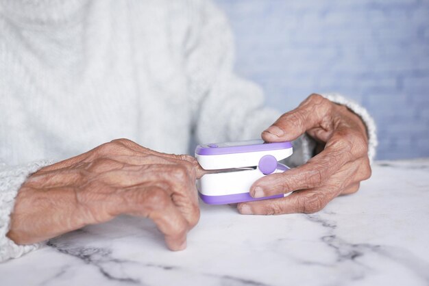 Senior giovani donne mano utilizzando pulsossimetro