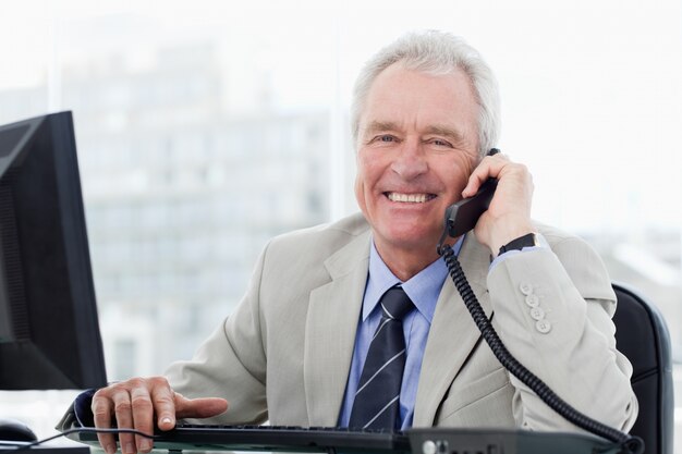 Senior manager sorridente al telefono