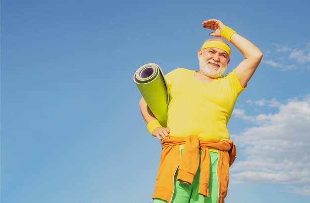 Senior uomo che si esercita sul cielo blu nonno sportivo su sfondi cielo blu sport e pensionamento