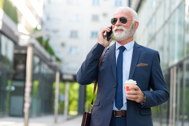 Senior uomo d'affari che parla al telefono con il cliente