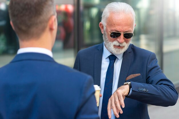 Senior uomo d'affari guardando orologio da polso