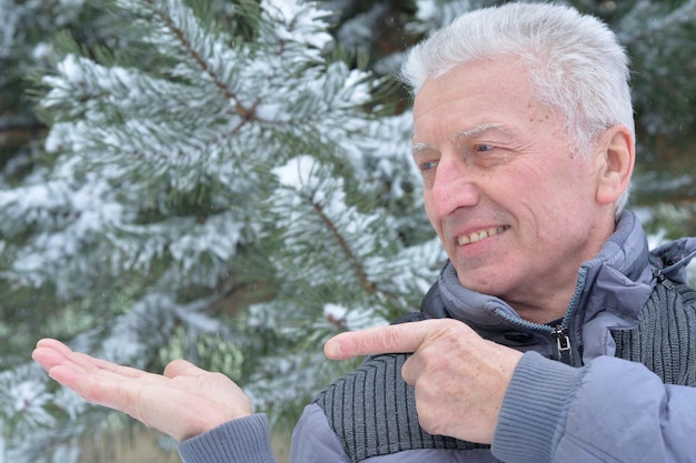 Senior uomo felice in posa all'aperto in inverno