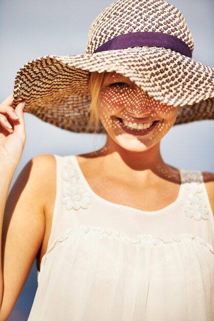 Sensazione estiva Una splendida giovane donna che indossa un cappello di paglia sotto il sole estivo