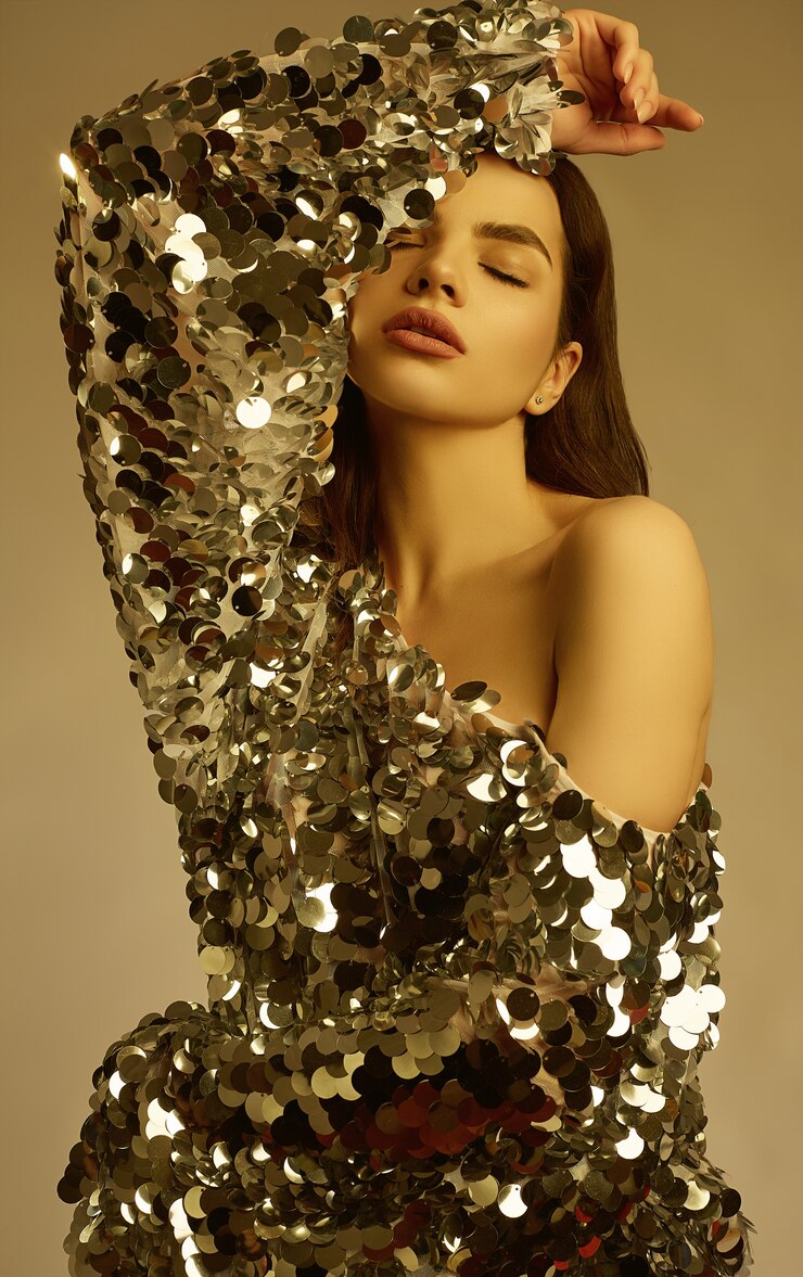 Sensuale bella donna bruna in un abito di moda lucido di paillettes