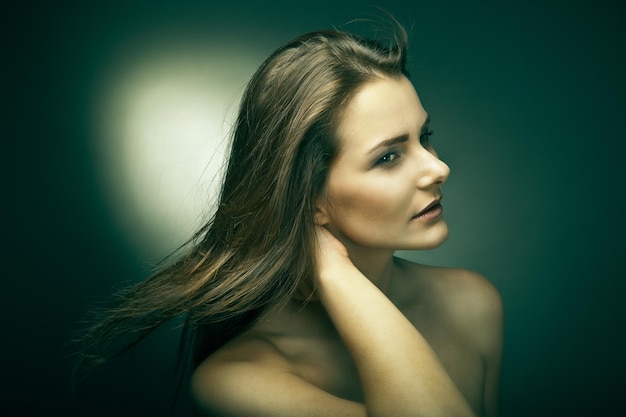 Sensuale giovane donna con bei capelli castani lunghi in posa Studio girato