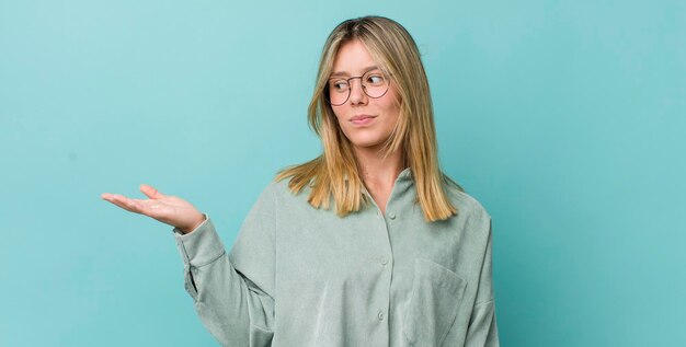 Sentendosi felice e sorridente guardando casualmente un oggetto o un concetto tenuto sulla mano sul lato