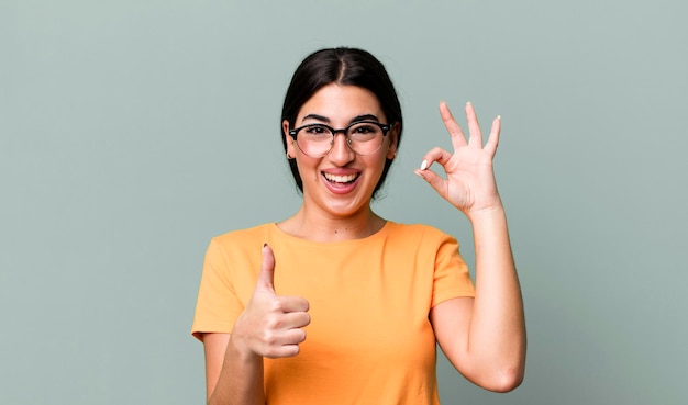 Sentendosi felice stupito soddisfatto e sorpreso mostrando gesti ok e pollice in alto sorridendo