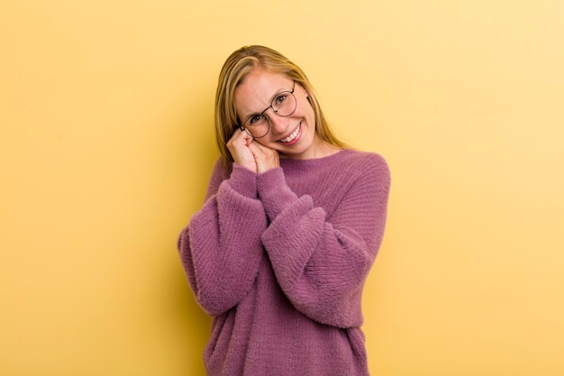 Sentendosi innamorato e sembrando carino adorabile e felice sorridente romanticamente con le mani accanto al viso