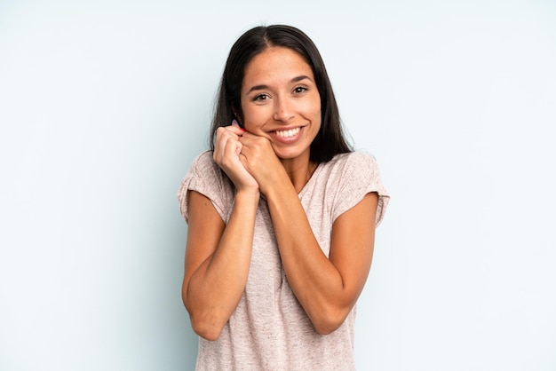 Sentendosi innamorato e sembrando carino adorabile e felice sorridente romanticamente con le mani accanto al viso