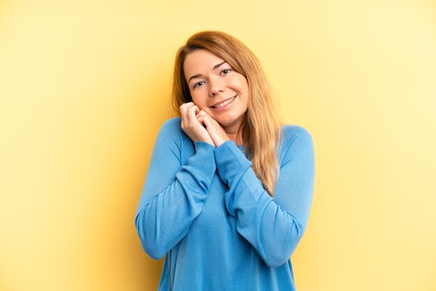 Sentendosi innamorato e sembrando carino adorabile e felice sorridente romanticamente con le mani accanto al viso