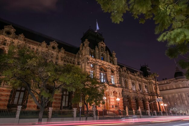 Sentieri di luce sulla strada vicino a un edificio storico di notte