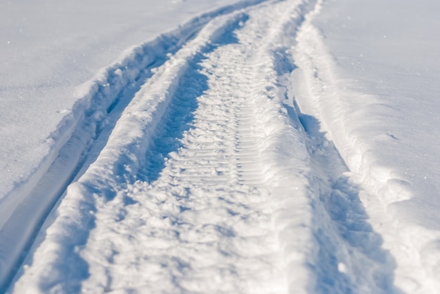 Sentiero in motoslitta su neve bianca profonda